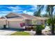 Front exterior of a charming home with a two-car garage and well-maintained landscaping at 1020 New Winsor Loop # 46, Sun City Center, FL 33573