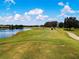 Scenic golf course view with lush green fairways, a tranquil lake, and beautiful community homes at 1020 New Winsor Loop # 46, Sun City Center, FL 33573