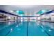 Bright indoor swimming pool with clear blue water and ample deck space at 1020 New Winsor Loop # 46, Sun City Center, FL 33573