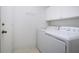 Laundry area featuring a white washer and dryer with white cabinets and tile flooring at 1020 New Winsor Loop # 46, Sun City Center, FL 33573