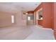 Spacious living room with neutral carpet, and easy access to a connected kitchen area with terra cotta walls at 1020 New Winsor Loop # 46, Sun City Center, FL 33573