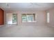 Spacious open-concept living area featuring plush carpeting, neutral paint, large windows, and access to the screened lanai at 1020 New Winsor Loop # 46, Sun City Center, FL 33573