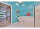 Bright bathroom featuring vibrant turquoise walls, white flooring, and a walk-in shower at 1034 Mcdaniel St # 1034, Sun City Center, FL 33573