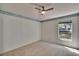 Neutral bedroom with trim along ceiling, light carpet, and small window at 1034 Mcdaniel St # 1034, Sun City Center, FL 33573