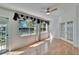 Sunlit living room features wood floors, ceiling fan, and sliding glass doors with a view of the yard at 1034 Mcdaniel St # 1034, Sun City Center, FL 33573