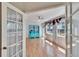 Bright sunroom features hardwood floors, large windows, and white french doors at 1034 Mcdaniel St # 1034, Sun City Center, FL 33573
