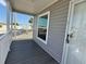 Inviting front porch with gray wood deck, white railings and gray siding offers outdoor enjoyment at 105 W Saint Johns Way, Apollo Beach, FL 33572