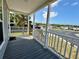 Relaxing covered front porch with white railings and gray wood deck is great for outdoor seating at 105 W Saint Johns Way, Apollo Beach, FL 33572