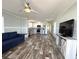 Open-concept living space featuring modern flooring, ceiling fan, and a comfortable blue sofa at 105 W Saint Johns Way, Apollo Beach, FL 33572