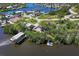 Aerial view of a waterfront home featuring a private dock and lush landscaping, showcasing waterfront living at 107 6Th Nw St, Ruskin, FL 33570