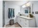 Bright bathroom featuring a white vanity with granite countertop, a decorative mirror, and a glass-enclosed shower at 107 6Th Nw St, Ruskin, FL 33570