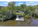 Aerial view of dock with a dock ladder into the water surrounded by thick green trees at 107 6Th Nw St, Ruskin, FL 33570