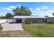 Charming single-story home featuring a well-manicured lawn, metal roof, and a welcoming front entryway at 107 6Th Nw St, Ruskin, FL 33570