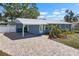 Beautiful home with a metal roof, brick driveway, covered parking, and vibrant landscaping at 107 6Th Nw St, Ruskin, FL 33570