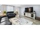 Cozy living room with a sleek entertainment center, plush seating, and contemporary rug at 107 6Th Nw St, Ruskin, FL 33570