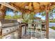 Well-equipped outdoor kitchen with a grill, bar seating, and a view of the water, perfect for entertaining at 107 6Th Nw St, Ruskin, FL 33570