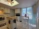 Bright kitchen featuring tile flooring, kitchen island, and sunlit window at 111 Lakeside Colony Dr, Tarpon Springs, FL 34689