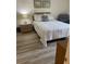 Cozy bedroom featuring a queen bed, nightstand, and updated flooring at 111 Woodland Pl, Osprey, FL 34229