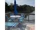 Outdoor deck overlooking the water, furnished with a dining set and a colorful umbrella at 111 Woodland Pl, Osprey, FL 34229