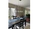 Bright dining room featuring an elegant light fixture, a modern table setting, and sliding glass doors at 111 Woodland Pl, Osprey, FL 34229