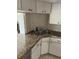 A kitchen showcasing granite countertops, white cabinetry, stainless steel sink, and tiled backsplash design at 111 Woodland Pl, Osprey, FL 34229