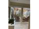 Interior view looking out to a furnished patio with a pergola, lush plants, and comfortable outdoor seating at 111 Woodland Pl, Osprey, FL 34229