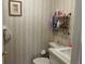 Charming half bathroom with patterned wallpaper, a vanity sink, and classic fixtures at 11450 Harbor Way # 5002, Largo, FL 33774