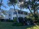 An exterior view of a multi-story home with lush greenery and bright sunlight peering through the mature trees at 11450 Harbor Way # 5002, Largo, FL 33774