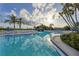 A large outdoor swimming pool and deck area with lounge chairs, palm trees, and a clear blue sky at 11450 Harbor Way # 5002, Largo, FL 33774