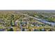 Aerial view showcasing a residential area with neatly arranged homes, green trees, and roads nearby at 1360 Overbrook Rd, Englewood, FL 34223