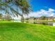 Scenic water view with lush green lawn and classic brick townhomes under a partly cloudy sky at 13719 Juniper Blossom Dr, Tampa, FL 33618