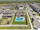 Aerial view of a backyard featuring a private pool, patio furniture, and a lush green lawn at 14637 Red Castle Ave, Lithia, FL 33547