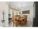 Elegant dining room featuring stylish wood-look tile, modern chandelier, and neutral decor to complement the natural light at 14637 Red Castle Ave, Lithia, FL 33547