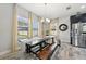 Dining room features large windows, wood floors, and a long table with bench seating, bathed in natural light at 14637 Red Castle Ave, Lithia, FL 33547