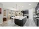 Open kitchen with a large center island, dark cabinetry, pendant lighting, and stainless steel appliances at 14637 Red Castle Ave, Lithia, FL 33547