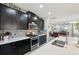 Kitchen showcasing stainless steel appliances, dark cabinets, mosaic tile backsplash, and quartz countertops at 14637 Red Castle Ave, Lithia, FL 33547