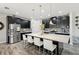 Spacious kitchen featuring black cabinetry, stainless steel appliances, and a large quartz countertop island with seating at 14637 Red Castle Ave, Lithia, FL 33547