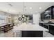 Open kitchen featuring a large center island, dark cabinetry, pendant lighting, and stainless steel appliances at 14637 Red Castle Ave, Lithia, FL 33547