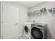 Bright laundry room featuring side-by-side washer and dryer and storage shelves at 14637 Red Castle Ave, Lithia, FL 33547