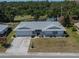 An aerial view showcasing the property, landscaping, and nearby green spaces and pond at 1508 W Del Webb Blvd, Sun City Center, FL 33573