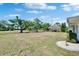 Large grassy backyard with mature trees and view of golf course pond providing a relaxing outdoor retreat at 1508 W Del Webb Blvd, Sun City Center, FL 33573