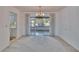 Open dining room area featuring neutral carpet, chandelier lighting, and glass doors to the sunroom, perfect for entertaining at 1508 W Del Webb Blvd, Sun City Center, FL 33573
