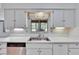 Bright kitchen featuring a stainless steel sink, white cabinetry, and a garden view window at 1508 W Del Webb Blvd, Sun City Center, FL 33573