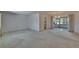 Open living room area with neutral carpet, glass doors to the sunroom, and chandelier, blending comfort and functionality at 1508 W Del Webb Blvd, Sun City Center, FL 33573