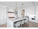 A bright kitchen featuring a marble island with seating, pendant lights, and stainless steel appliances at 16119 6Th E St, Redington Beach, FL 33708