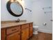 Bathroom vanity featuring a round mirror and granite countertop with wood-look flooring at 1924 E View Dr, Sun City Center, FL 33573