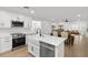 Bright, white kitchen with stainless steel appliances and a breakfast bar that overlooks the dining area at 201 Flamingo Dr, Belleair, FL 33756