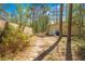 View of the backyard showing a metal garage building and wooden fence surrounded by trees at 20354 Gamble Dr, Brooksville, FL 34601