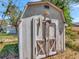 Close-up of wooden shed with distressed double doors, offering outdoor storage at 2127 Alemanda Dr, Clearwater, FL 33764