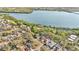 Stunning aerial view showcases waterfront homes, lush trees, and tranquil lake in a desirable community at 230 Lotus Dr, Safety Harbor, FL 34695